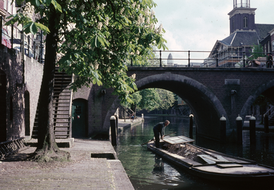 849822 Afbeelding van een schuit in de Oudegracht te Utrecht, ter hoogte van de Jacobibrug.N.B. Op de steen in de brug ...